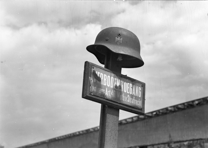 836316 Afbeelding van een oude helm van de Wehrmacht boven een bordje verboden toegang bij de stortplaats van de VAM ...
